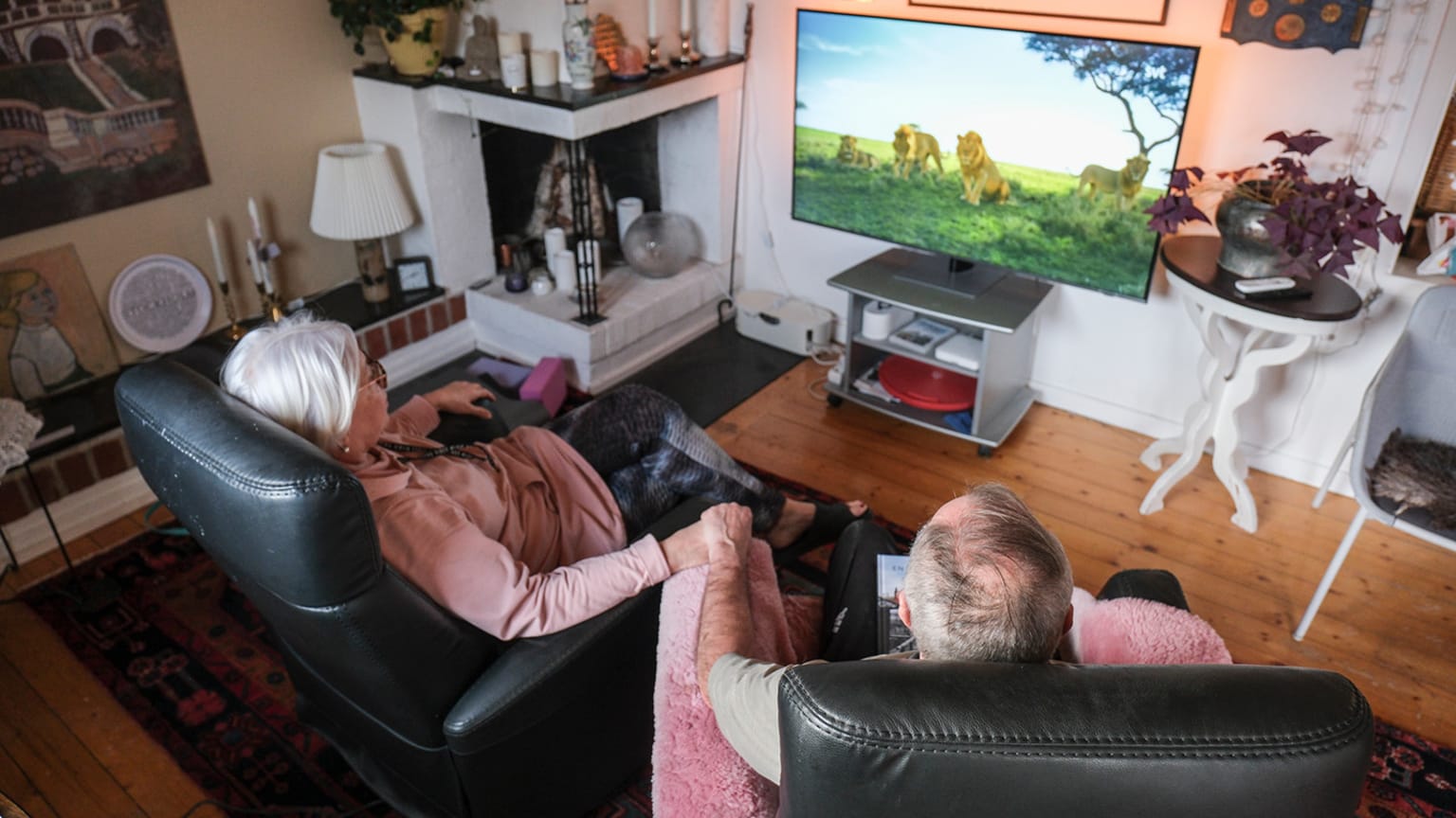 En kvinna med två barn hackar grönsaker vid köksbord