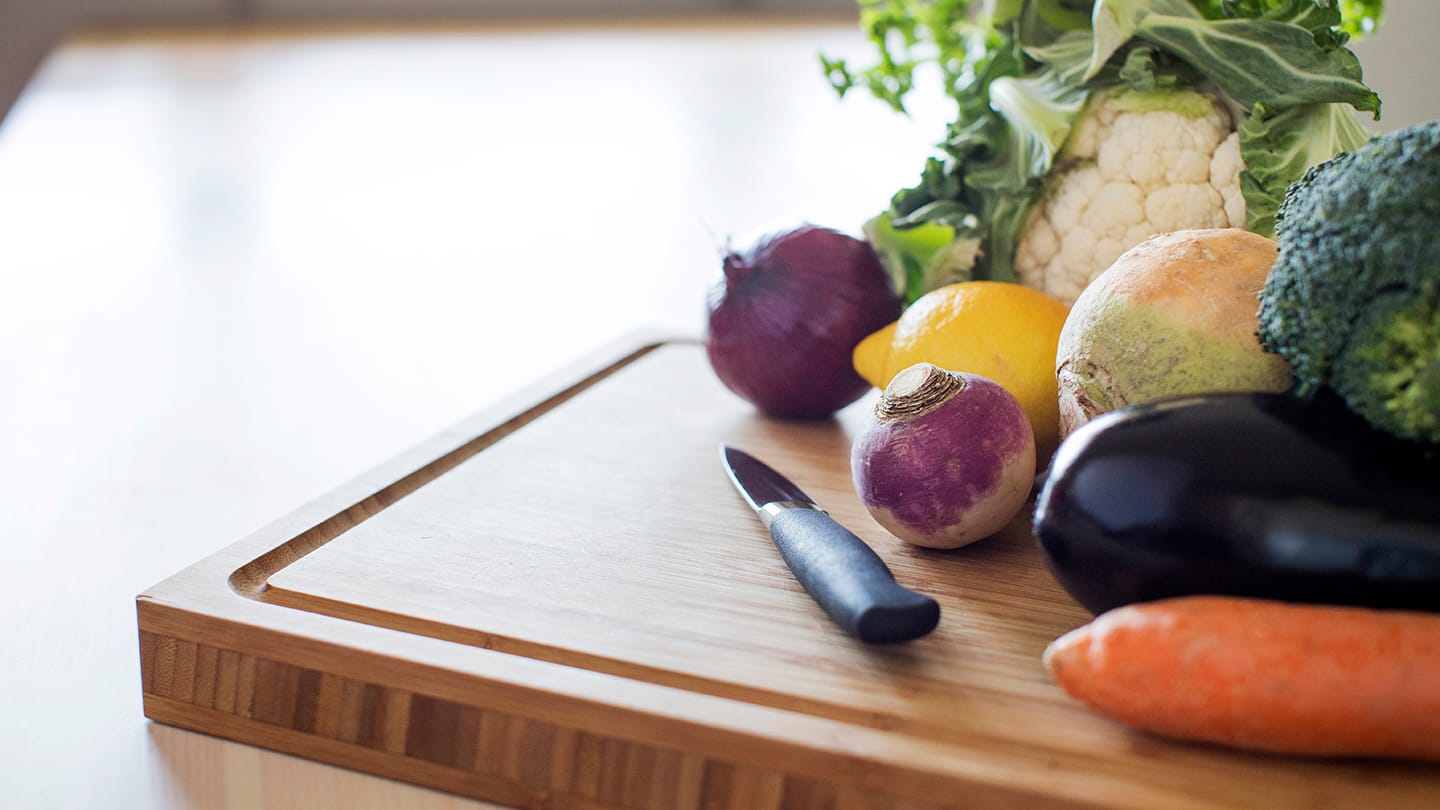 Olika grönsaker och rotfrukter på en skärbräda