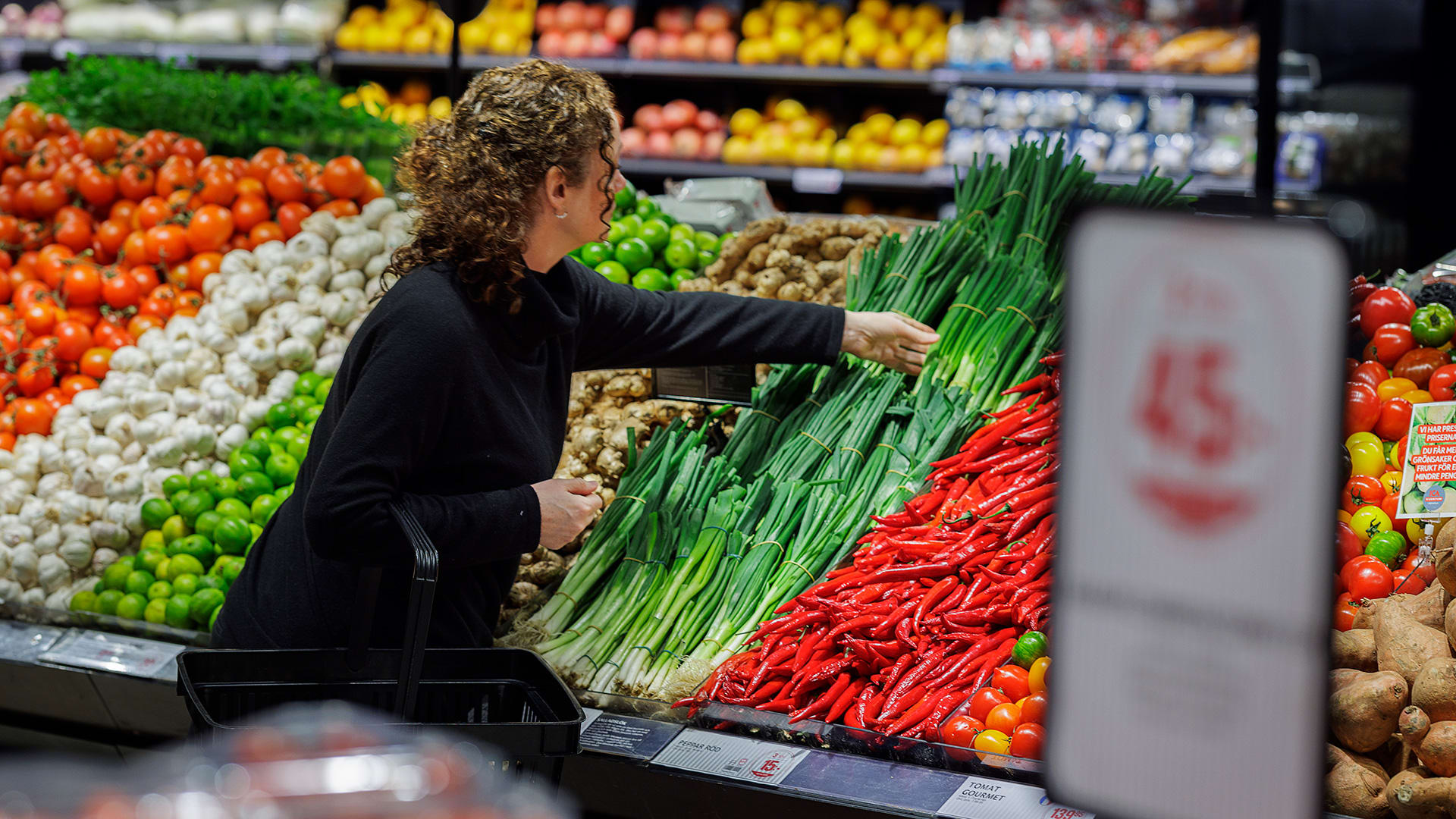 En kvinna handlar grönsaker i en butik