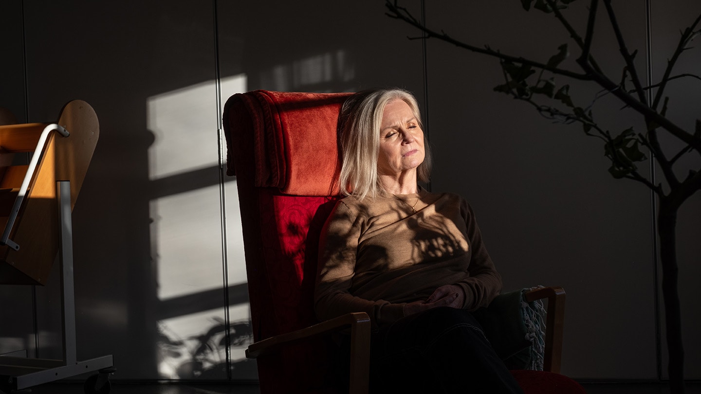 Kvinna sitter i en fåtölj i solljus