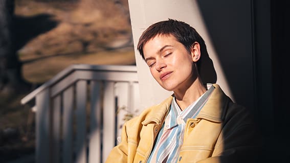 kvinna som blundar mot solen